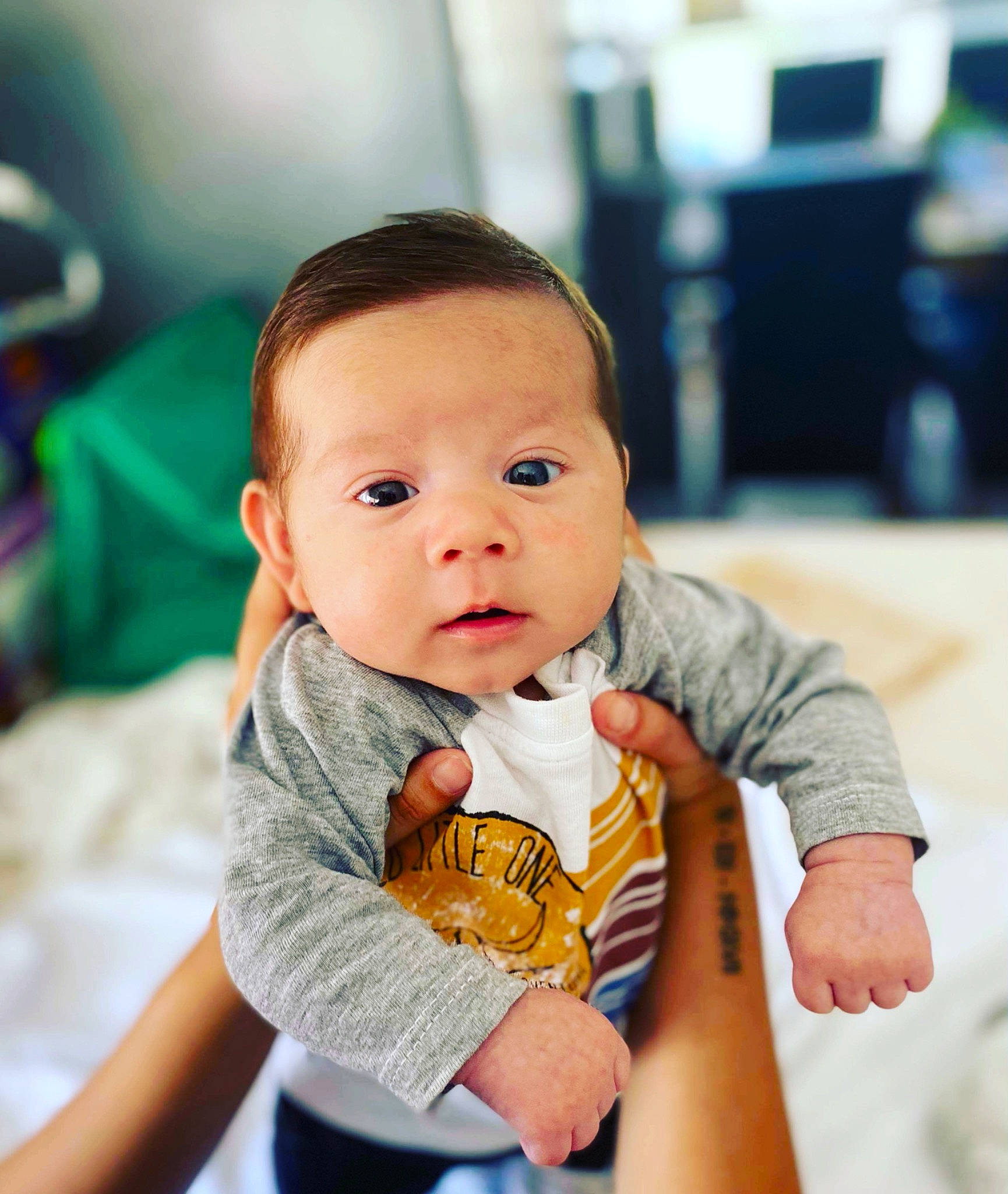 Kobeigh is registered to the contest to win money with this photo: baby, baby_toddler_clothing, cheek, child, chin, collar, comfort, face, facial_expression, finger, flash_photography, hairstyle, happy, iris, neck, person, sitting, skin, sleeve, t_shirt