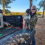 Tully Hart joined the competition — help win amazing prizes! woman, dog, pickup_truck, hunting, birds, outdoor, trees, forest, nature, camouflage_clothing, hat, leash, smile, field, sky, wildlife, animal, pet, rural, hunting_trip