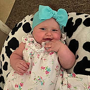 Payton joined the competition — help win amazing prizes! baby, child, headband, bow, floral_dress, cushion, black_and_white, cheeks, hand, face, indoor, comfort, cute, infant, pattern, textile, relaxation, portrait, young, smile