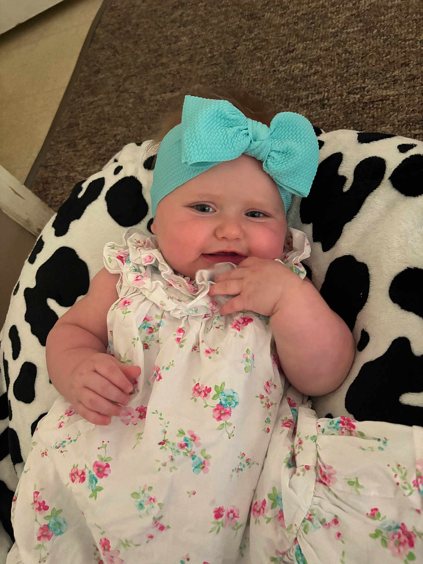 Payton joined the competition — help win amazing prizes! baby, child, headband, bow, floral_dress, cushion, black_and_white, cheeks, hand, face, indoor, comfort, cute, infant, pattern, textile, relaxation, portrait, young, smile