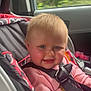 Payton is registered to the contest to win money with this photo: baby, child, car_seat, seat_belt, blonde_hair, blue_eyes, smiling, pink_clothing, car_interior, window, seat, safety_harness, infant, cute, face, person, transportation, vehicle, happy, indoors