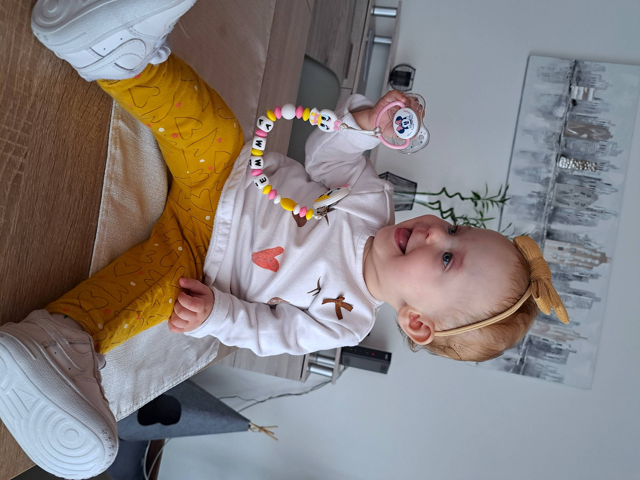 Emma participe au concours pour gagner de l'argent avec cette photo : baby, baby_products, baby_toddler_clothing, child, comfort, elbow, finger, fun, gesture, glove, hat, human_leg, knee, mouth, person, room, thigh, thumb, toddler, uniform