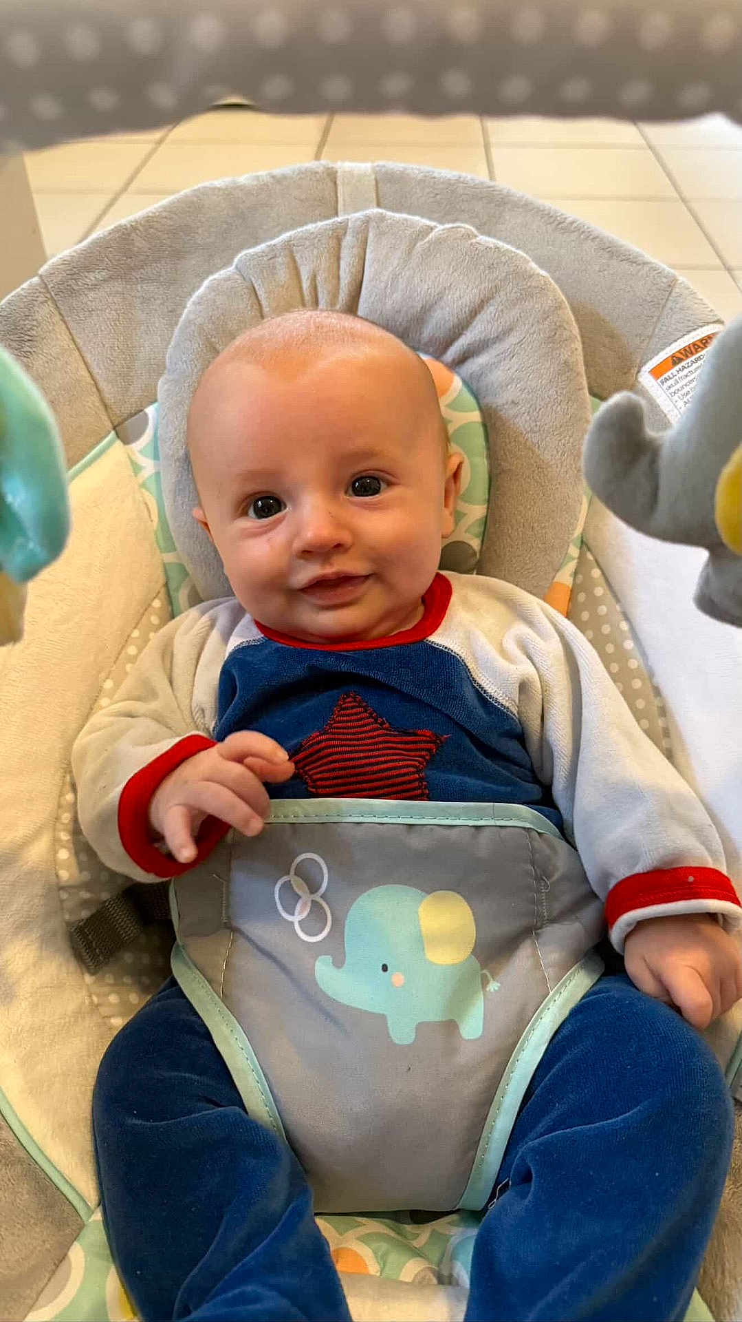 Rafael a rejoint le concours — aidez-le/la à gagner de superbes lots ! baby, infant, child, smile, face, blue_clothing, star_pattern, elephant_toy, baby_seat, seatbelt, indoor, floor_tiles, hand, cute, young, portrait, cozy, comfort, playful, bright_eyes