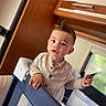 Kaïs a rejoint le concours — aidez-le/la à gagner de superbes lots ! toddler, child, indoor, playpen, toy, hairstyle, mohawk, gold_chain, curious, clothing, buttoned_shirt, face, hand, window, wooden_cabinet, furniture, person, young_child, expression, home