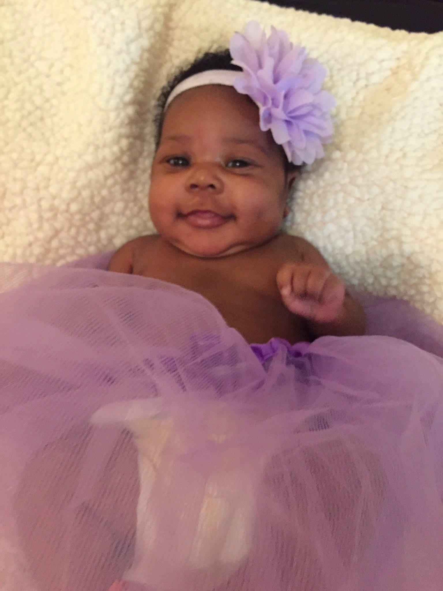 Bria is registered to the contest to win money with this photo: baby, child, costume, face, fun, hair_accessory, head, headgear, headpiece, lavender, lilac, linens, person, pink, purple, skin, smile, textile, toddler