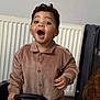toddler, child, happy, indoor, curly_hair, earrings, toy, steering_wheel, brown_jacket, radiator, luggage, excited, person, playtime, smiling, buttoned_shirt, home, young_child, expression, cheerful