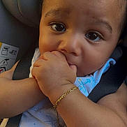 Isaac a rejoint le concours — aidez-le/la à gagner de superbes lots ! baby, child, car_seat, hand_in_mouth, bracelet, curly_hair, close_up, infant, cute, portrait, seatbelt, blue_outfit, airplane_pattern, skin, young_child, looking_at_camera, indoor, soft_lighting, adorable, person