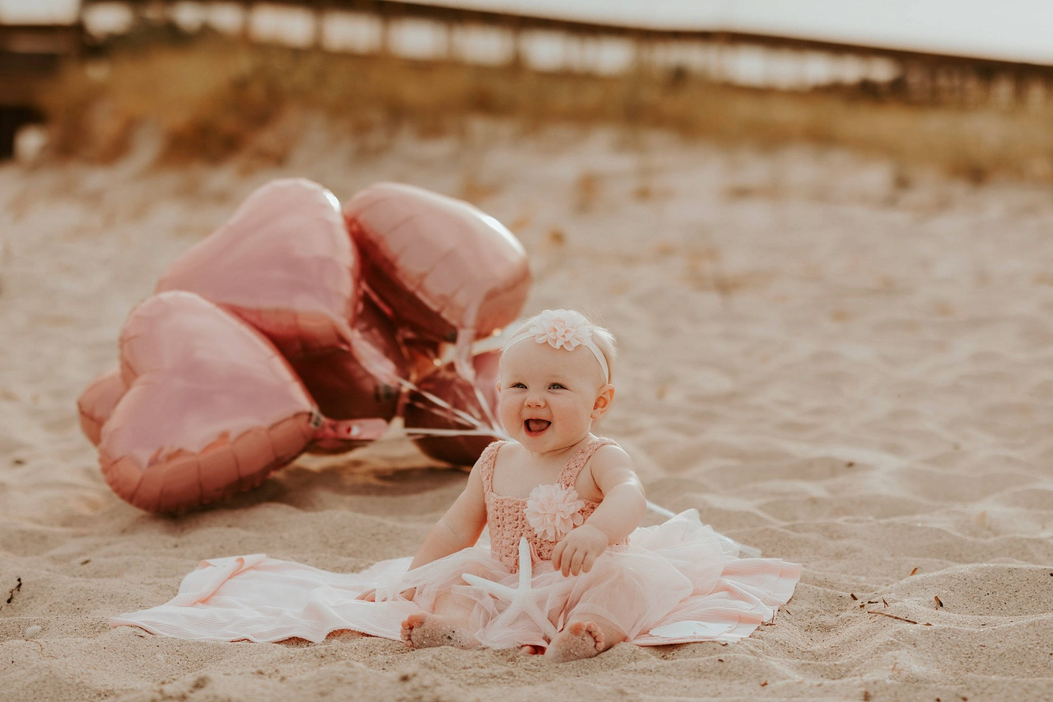 Vivian is registered to the contest to win money with this photo: baby, beach, cap, child, dress, fashion_accessory, flash_photography, fun, grass, happy, hat, headpiece, landscape, leisure, people_in_nature, person, personal_protective_equipment, petal, sand, toddler