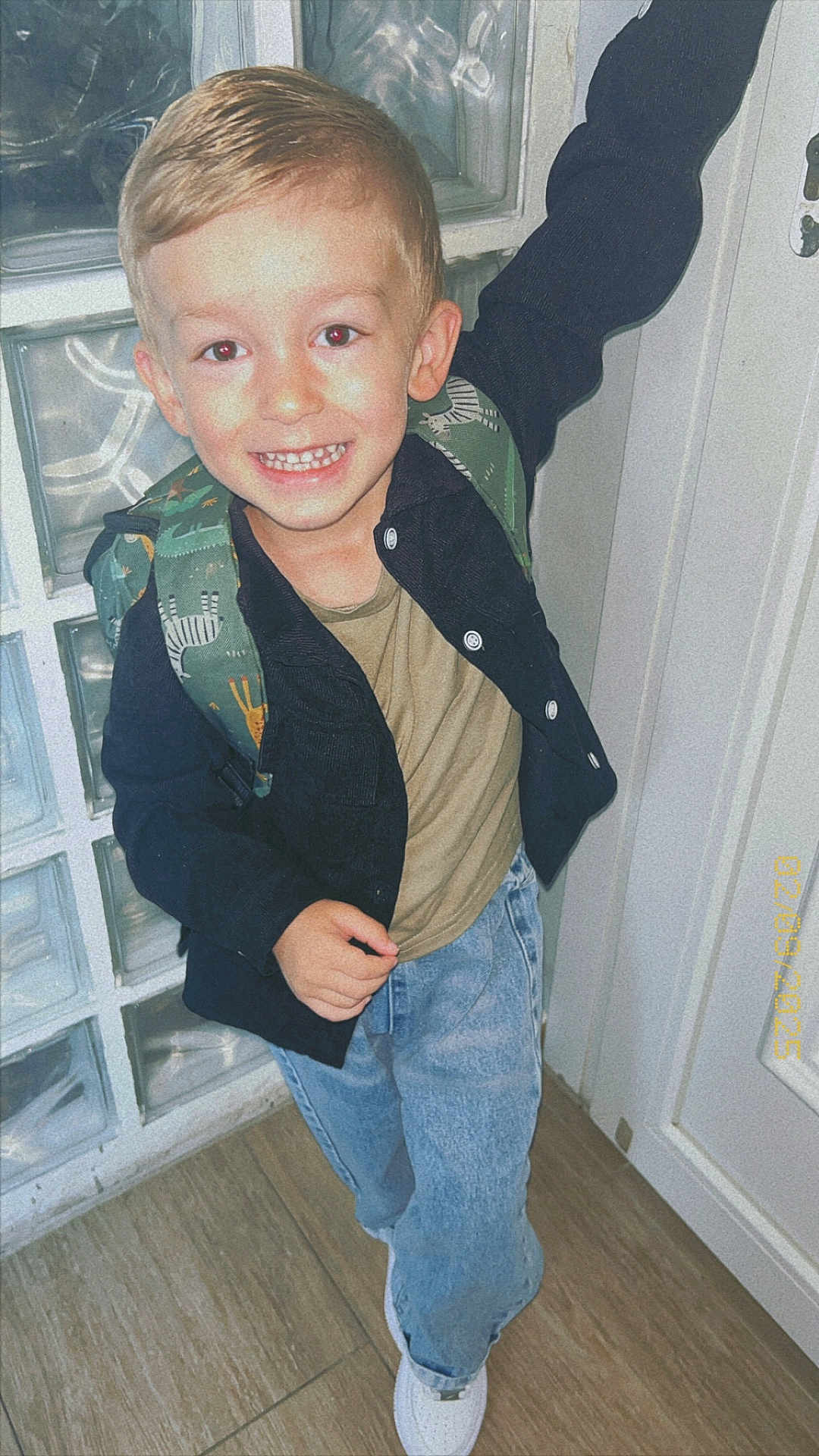 Nëlyo a rejoint le concours — aidez-le/la à gagner de superbes lots ! child, boy, smile, backpack, jeans, jacket, indoor, wooden_floor, door, glass_blocks, casual_clothing, happy, posing, young, footwear, white_shoes, portrait, standing, light_skin, short_hair