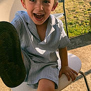 Nëlyo participe au concours pour gagner de l'argent avec cette photo : child, boy, smiling, hat, cap, chair, outdoor, sunlight, happy, foot, playful, summer, clothing, grass, concrete, person, casual, daylight, young, fun