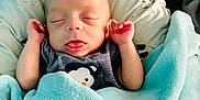 Mathis participe au concours pour gagner de l'argent avec cette photo : baby, infant, blanket, sleeping, tongue_out, hands, cushion, soft, cozy, cute, indoors, clothing, fabric, comfort, rest, person, newborn, peaceful, wrapped, head