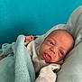 baby, infant, blanket, blue, cozy, cute, tongue_out, cushion, soft, sleepwear, person, newborn, skin, head, hand, expression, indoors, portrait, resting, child