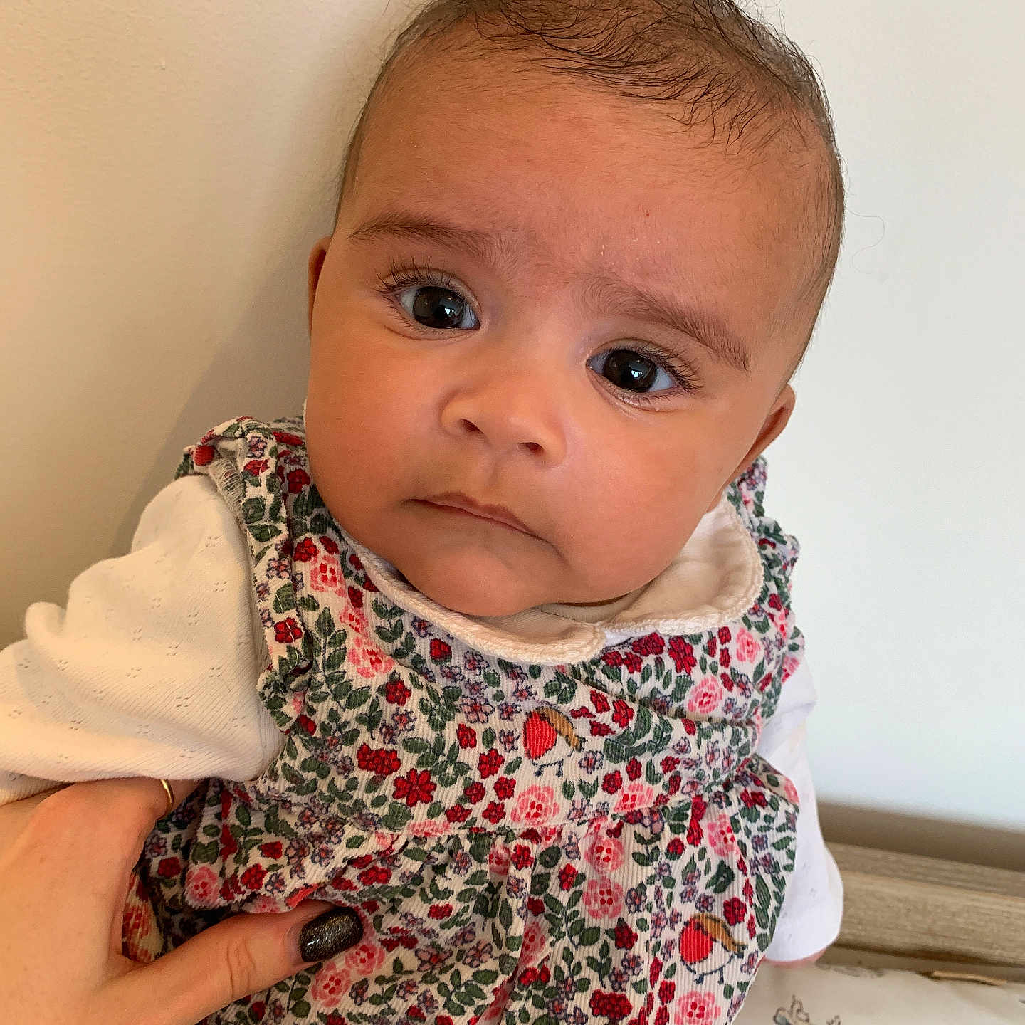 Ezri is registered to the contest to win money with this photo: accessories, applique, baby, bib, blanket, blouse, bodypart, bonnet, clothing, couch, dress, face, finger, frown, furniture, hand, happy, hat, head, headband