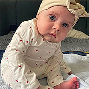 Adèle a rejoint le concours — aidez-le/la à gagner de superbes lots ! baby, bed, blanket, blue_eyes, child, closeup, clothing, couch, cute, expression, face, foot, head, headband, indoor, infant, pajamas, person, sitting, skin