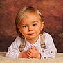 toddler, child, blonde_hair, blue_eyes, white_shirt, suspenders, portrait, smile, hands, fluffy_blanket, indoor, studio, background, cute, young_child, person, baby, fashion, innocent, soft_lighting