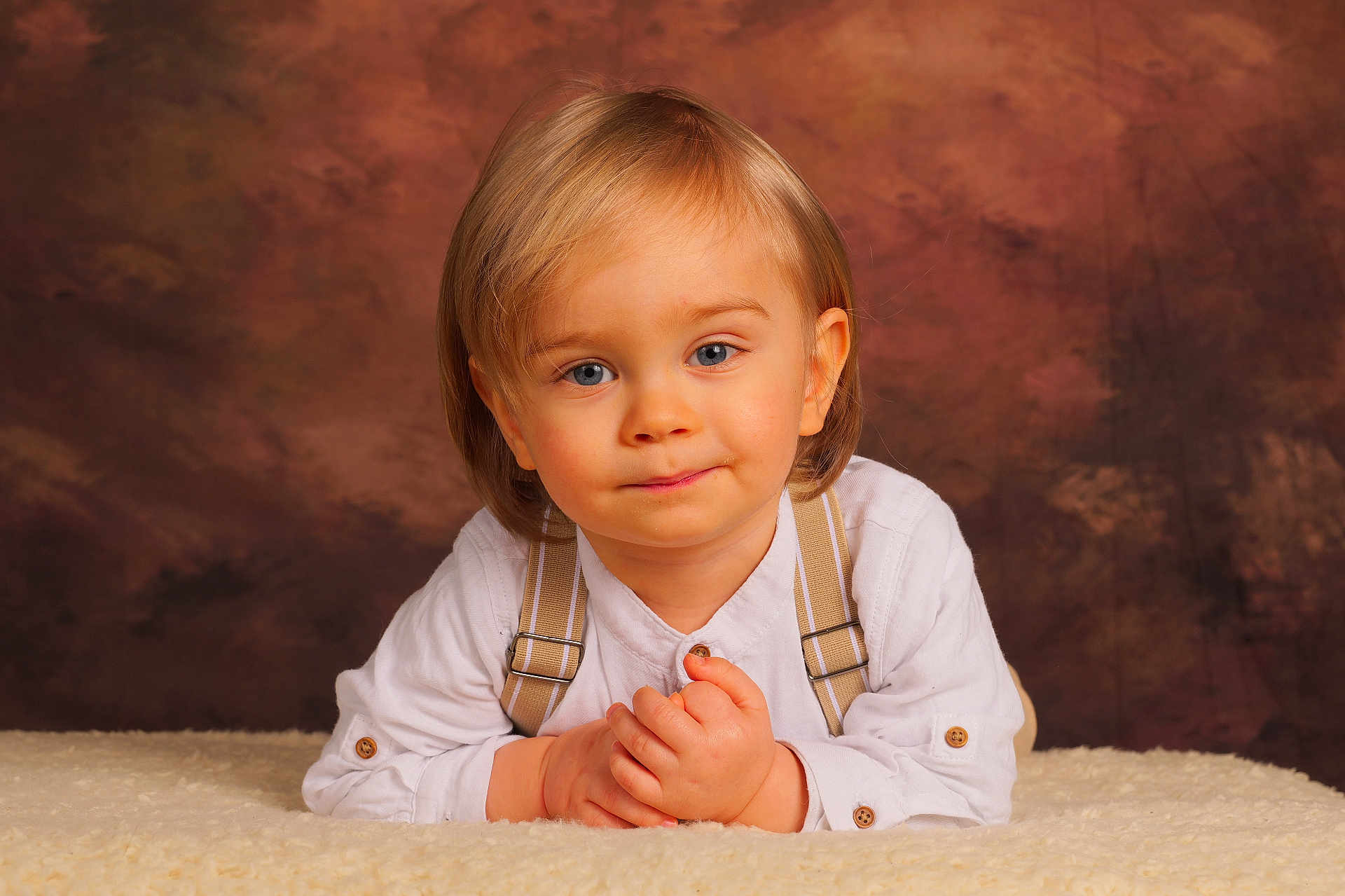 Lowen a rejoint le concours — aidez-le/la à gagner de superbes lots ! toddler, child, blonde_hair, blue_eyes, white_shirt, suspenders, portrait, smile, hands, fluffy_blanket, indoor, studio, background, cute, young_child, person, baby, fashion, innocent, soft_lighting