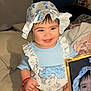 Aisha is registered to the contest to win money with this photo: baby, child, smiling, hat, blue_clothing, white_sandals, bed, blanket, smartphone, portrait, indoors, cute, happy, infant, sitting, hand, face, person, photography, accessory