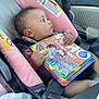 baby, child, car_seat, book, reading, seatbelt, pink, interior, car, safety, infant, cute, portrait, side_view, holding, colorful, young_child, clothing, pacifier, blanket