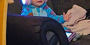 Alfie is registered to the contest to win money with this photo: toddler, child, headphones, glowing, cat_ears, blue_onesie, couch, tablet, blanket, indoor, furniture, wooden_door, chair, cozy, technology, person, seated, expression, living_room, home