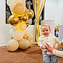 toddler, child, balloons, celebration, indoor, carpet, curtains, window, cross, dove, smile, shirt, jeans, shoes, adult_hands, decor, lighting, party, standing, happy