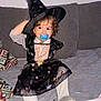 child, costume, couch, curly_hair, cute, dress, fun, gray_couch, hat, home, indoor, pacifier, playful, portrait, sitting, stars_pattern, toddler, white_tights, witch_costume, young_child