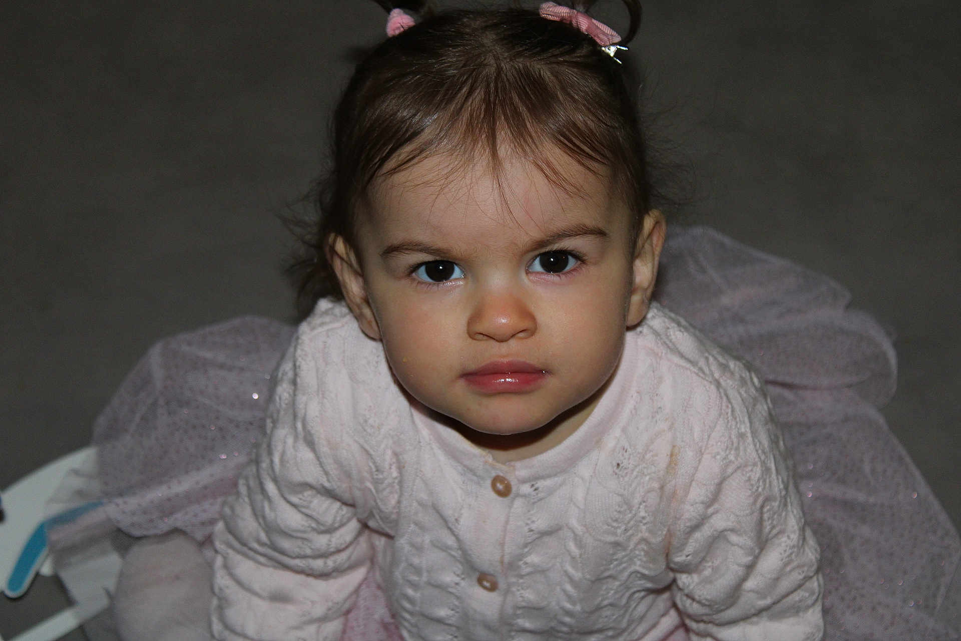 Inaya participe au concours pour gagner de l'argent avec cette photo : baby, child, closeup, clothing, cute, expression, eyes, face, floor, hair, indoor, person, pink, portrait, sitting, skin, sweater, toddler, tutu, young