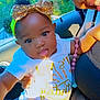 baby, bow, car_interior, child, clothing, cute, face, greenery, hand, happy, headband, nature_outside, person, portrait, seat, smile, socks, sunlight, window, yellow