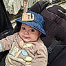 baby, hat, blue_hat, car_seat, clothing, baby_clothes, price_tag, store, shopping, child, infant, cute, wide_eyes, curious, mischievous, seated, indoor, fabric, person, retail