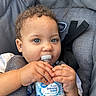 toddler, child, baby, water_bottle, car_seat, curly_hair, blue_eyes, hands, face, seatbelt, gray, drinking_water, plastic_bottle, young_child, portrait, indoor, close_up, person, cute, infant