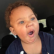 Sylver joined the competition — help win amazing prizes! baby, child, infant, portrait, face, eyes, wide_eyed, surprised, open_mouth, expression, curly_hair, earring, clothing, shirt, car, car_interior, seat, close_up, indoor, photography
