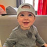 Tiago participe au concours pour gagner de l'argent avec cette photo : backwards_cap, cap, child, clothing, couch, curtain, face, grey_sweater, happy, indoor, living_room, person, play, seat, smile, stain, toddler, toy_car, window, young_child
