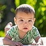 baby, background_blur, child, closeup, curious, cute, daylight, expression, eyes, face, greenery, infant, lying_down, nature, outdoor, portrait, skin, sunlight, tshirt, young