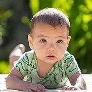 Max a rejoint le concours — aidez-le/la à gagner de superbes lots ! baby, child, infant, outdoor, sunlight, greenery, dinosaur_print, onesie, face, eyes, skin, hand, lying_down, portrait, cute, young, nature, expression, daylight, soft_focus