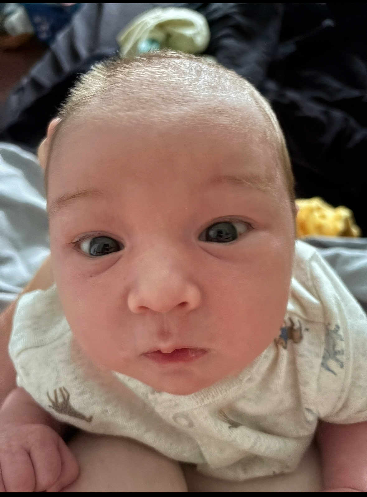 Kodawayne joined the competition — help win amazing prizes! baby, infant, face, eyes, onesie, clothing, skin, head, expression, cute, person, child, newborn, portrait, closeup, hand, indoor, soft_light, curious, young