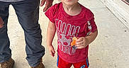 Rhyker joined the competition — help win amazing prizes! child, toddler, glasses, red_glasses, red_shirt, shorts, pacifier, sidewalk, brick_wall, tattoo, adult, boots, curious, outdoor, person, playful, window, reflection, concrete, urban