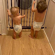 Mariska joined the competition — help win amazing prizes! baby, baby_gate, back_view, barefoot, child, curly_hair, diaper, doorframe, hair, hallway, home, indoor, infant, light, room, safety_gate, standing, toddler, wall, wooden_floor