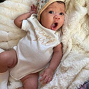 Anelé joined the competition — help win amazing prizes! baby, infant, onesie, hat, floral, blanket, soft, cozy, lying_down, expression, cute, child, sleepwear, white_clothing, sock, hand, face, skin, indoors, portrait