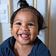Maayoan is registered to the contest to win money with this photo: baby, blue_shirt, button, child, closeup, clothing, cute, expression, eyes, face, hair, happy, indoor, person, portrait, skin, smile, tongue_out, topknot, young_child