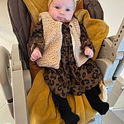 Lyna a rejoint le concours — aidez-le/la à gagner de superbes lots ! baby, infant, child, baby_chair, blanket, headband, bow, vest, dress, leopard_print, black_tights, indoors, floor_tiles, cushion, furniture, cute, portrait, young_child, clothing, seated