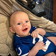 Axell joined the competition — help win amazing prizes! baby, child, infant, smiling, happy, portrait, stroller, football_uniform, sportswear, blue_clothing, indoors, tiled_floor, adult, legs, seated, reclining, close_up, face, family, photography