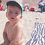toddler, child, beach, sand, bucket, cap, sunny, outdoor, play, person, diaper, towel, relaxing, people, summer, blue_sky, wall, building, casual, daytime
