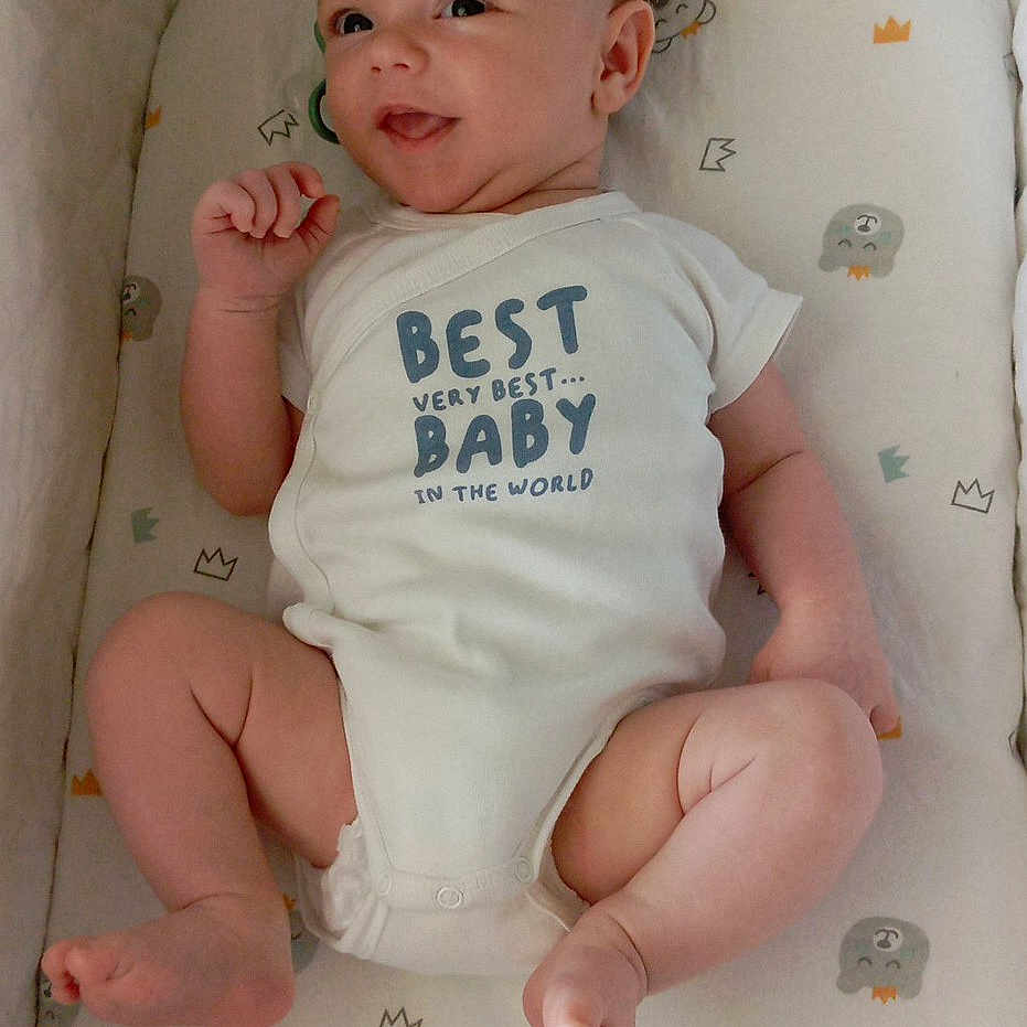 Johan participe au concours pour gagner de l'argent avec cette photo : baby, bed, child, comfortable, cushion, cute, expression, face, happy, indoors, infant, lying_down, newborn, onesie, pattern, skin, sleeping_area, small, smiling, soft
