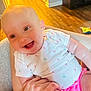 Laynie joined the competition — help win amazing prizes! baby, smiling, infant, white_shirt, pink_shorts, hand, indoor, flooring, wood_floor, person, child, happy, cute, holding, skin, face, eyes, expression, comfort, casual