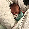 newborn, baby, sleeping, pacifier, blanket, swaddled, infant, cozy, cute, resting, soft, patterned_blanket, love_text, indoors, closeup, head, peaceful, child, wrapped, bed