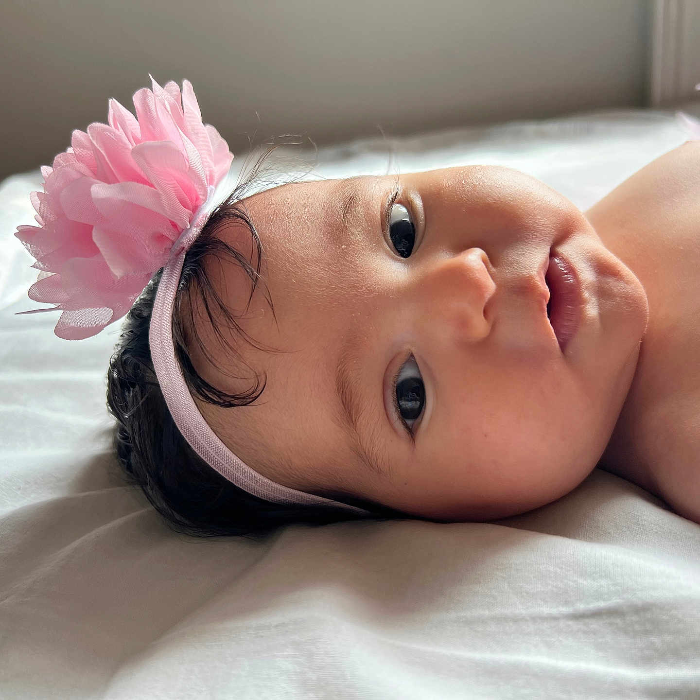 Cylia a rejoint le concours — aidez-le/la à gagner de superbes lots ! baby, infant, headband, flower, pink, lying_down, bed, white_bed, skin, face, eyes, soft_light, cute, child, portrait, indoors, newborn, young, head, expression