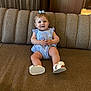 Ivy joined the competition — help win amazing prizes! baby, child, smiling, sitting, romper, blue_bow, white_sandals, sofa, brown_sofa, indoor, wood_paneling, happy, cute, infant, furniture, portrait, one_person, young_child, comfortable, casual_clothing