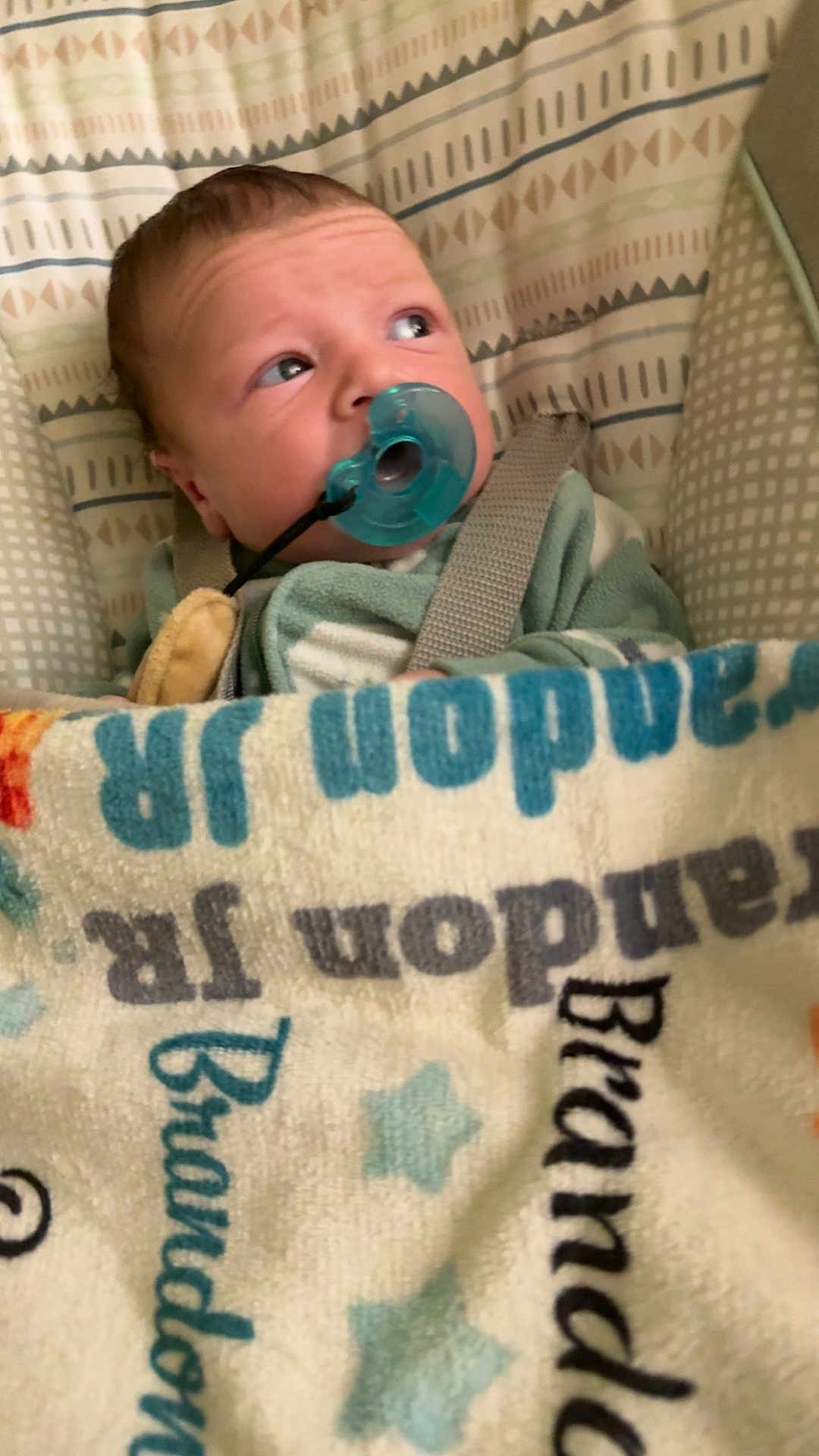 Brandon Jr joined the competition — help win amazing prizes! baby, pacifier, blanket, infant, child, face, blue, pattern, text, fabric, bed, cute, young, person, sleeping_bag, soft, closeup, wrapped, indoors, comfort