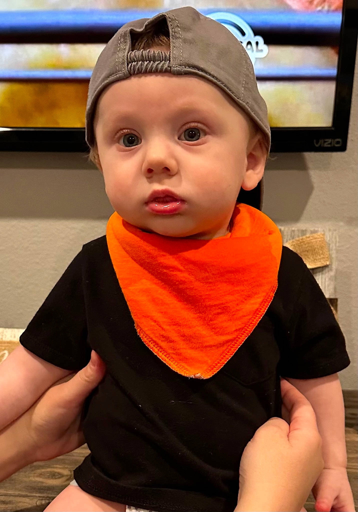 Cam is registered to the contest to win money with this photo: baby, baby_toddler_clothing, cap, cheek, child, eyelash, fashion_accessory, forehead, fun, happy, headwear, lifejacket, mouth, neck, nose, orange, person, personal_protective_equipment, sleeve, television