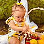 toddler, child, basket, lemons, strawberries, flowers, yellow_bow, hair_tie, outdoor, greenery, blanket, summer, fruit, cute, concentration, sitting, baby_clothes, nature, daylight, portrait