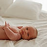 Banx is registered to the contest to win money with this photo: baby, infant, newborn, bed, pillow, white_bedspread, lying_down, skin, face, eyes, hand, arm, soft_light, indoors, cozy, peaceful, portrait, human, child, newborn_baby